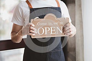 Man holding open close sign in front of entrance, Goods and Service shop clerk holding sign to notify customers whether the store