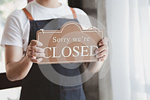 Man holding open close sign in front of entrance, Goods and Service shop clerk holding sign to notify customers whether the store