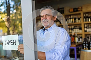 Man holding open sign in wine shop