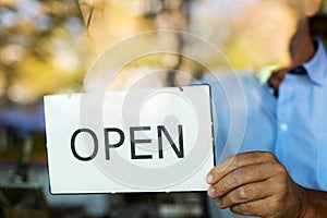 Man holding open sign in wine shop