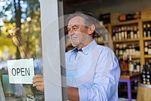 Man holding open sign in wine shop