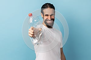 Man holding out plastic bottle, worrying about plastic recycling, environmental pollution.