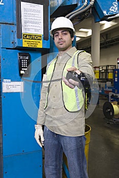 Man Holding Out Telephone Receiver In Factory