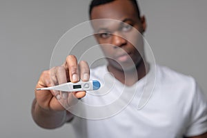 Man holding out thermometer to camera