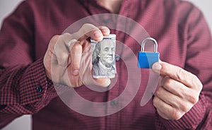 Man holding padlock with dollars. Financial security