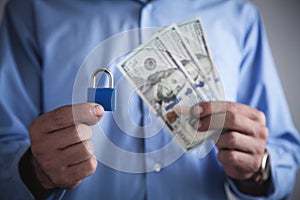 Man holding padlock with dollars. Financial security