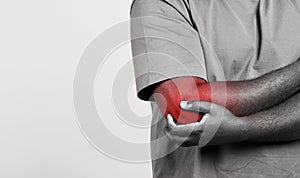 Man holding painful elbow with pain spot on white background