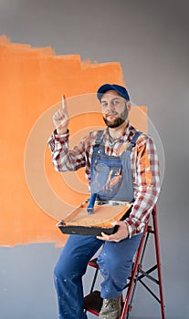 man holding painter roller surprised, pointing with finger-up photo