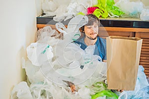 Man holding paper bag amid a pile of plastic bags. Zero waste concept. The concept of World Environment Day