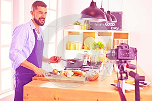 Man holding paper bag full of groceries on the kitchen background. Shopping and healthy food concept