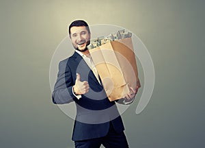 Man holding paper bag with money