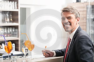 Man holding pen in front of bar counter