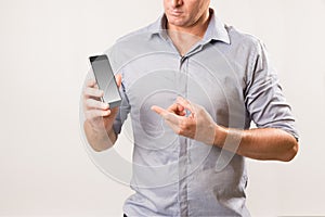 Man holding phone and pointing at the screen with other hand