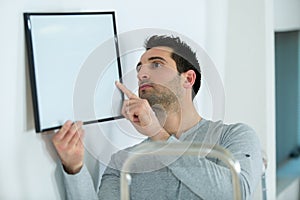 man holding picture frame