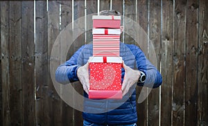 man holding pile of Christmas gift boxes