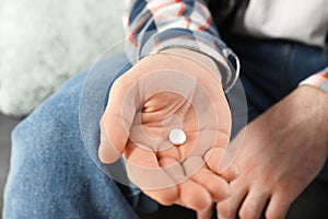 Man holding pill in hand, closeup view