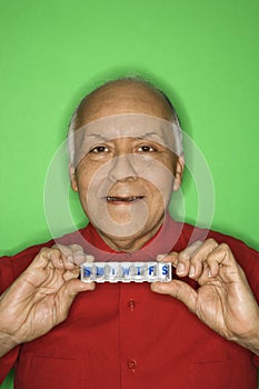 Man holding pill organizer.