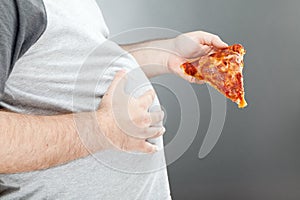 Man holding pizza and rubbing his belly