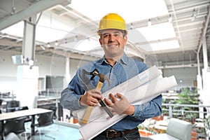 Man holding plans and tools