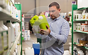 Man holding plastic gallon in hypermarket