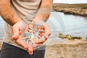 Man Holding Plastic waste from beach. Sustainability and Ecologist Concept.