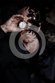 Man holding a pocket watch to his eyes and black smoke