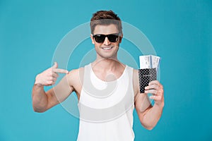 Man holding and pointing finger at passport with flying tickets