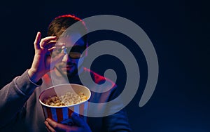 Man holding popcorn in 3D glasses. Film screenings, premieres. Poster photo with space for text.