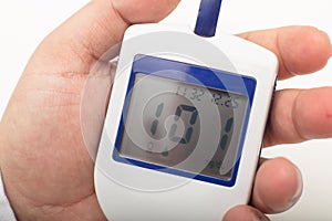Man holding a portable digital glucose meter