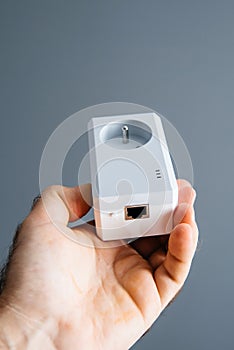 Man holding powerline Ethernet adapter gray background