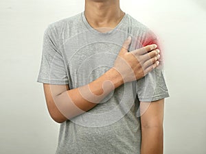 Man holding pressing his shoulder, pain ache from impingement syndrome