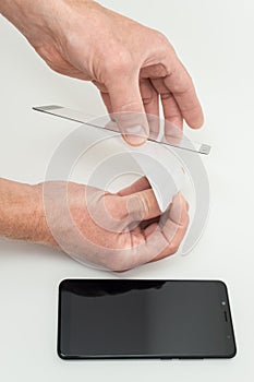 A man is holding a protective glass for a smartphone