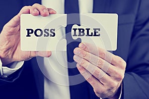 Man holding puzzle pieces with the word Possible