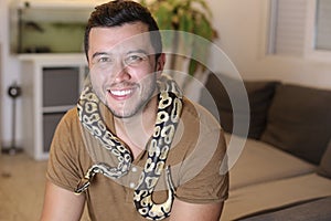 Man holding `python regius` or `ball python`