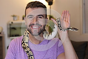 Man holding `python regius` or `ball python`