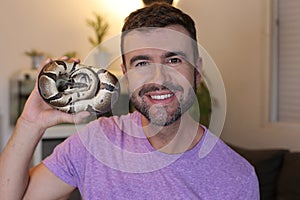 Man holding `python regius` or `ball python`