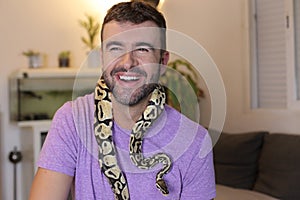 Man holding `python regius` or `ball python`