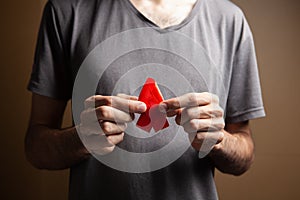 a man holding a red aids ribbon