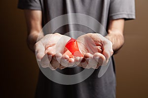 a man holding a red aids ribbon