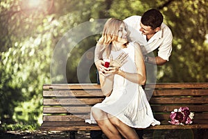 Man holding red box with ring making propose to his girlfriend