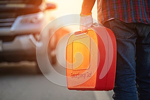 Man holding red emergency tools box and standing infront of car on the roadside. Car accident, repair and maintenance concept