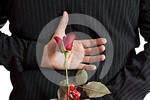 Man holding red rose behind his back