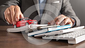 Man holding red toy car over business objects