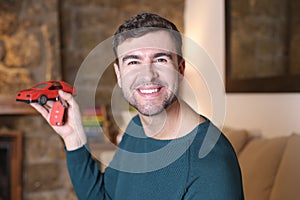 Man holding red toy sports car and keys