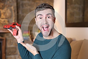 Man holding red toy sports car and keys