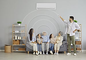 Man holding a remote control air conditioner makes a comfortable temperature for the family.