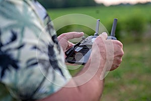 A man holding a remote control of a drone in his hand, close-up