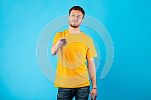 Man holding remote control isolated on blue background