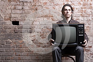 A man holding a retro television