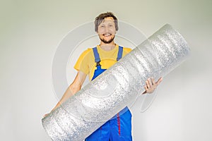 man holding a roll of insulating cloth to install a laminate wooden floor
